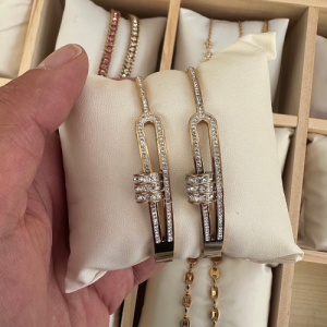 Un bracelet doré en acier inoxydable, au design moderne orné de zirconium étincelant. Élégant, résistant à l’eau et parfait pour briller en toute occasion.