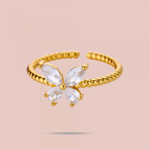 Élégante et délicate, cette bague dorée papillon en acier inoxydable est sertie de zirconium scintillant. Ajustable, résistante à l’eau et intemporelle.